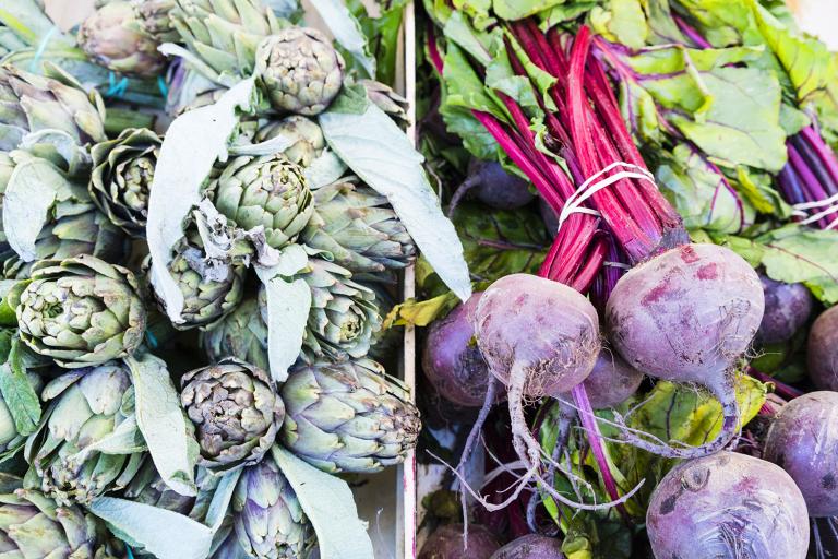 artichokes and beets in an open-air market